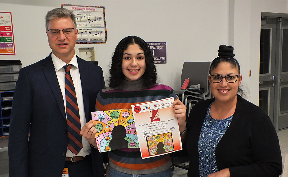Jacqueline Rivera holds her ‘Bubbles of Positivity’ art work while standing beside Principal Ryan Lawler and Myra Rivera.